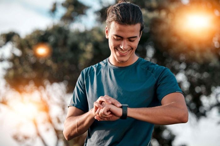Młody mężczyzna sprawdza smartwatch podczas biegania
