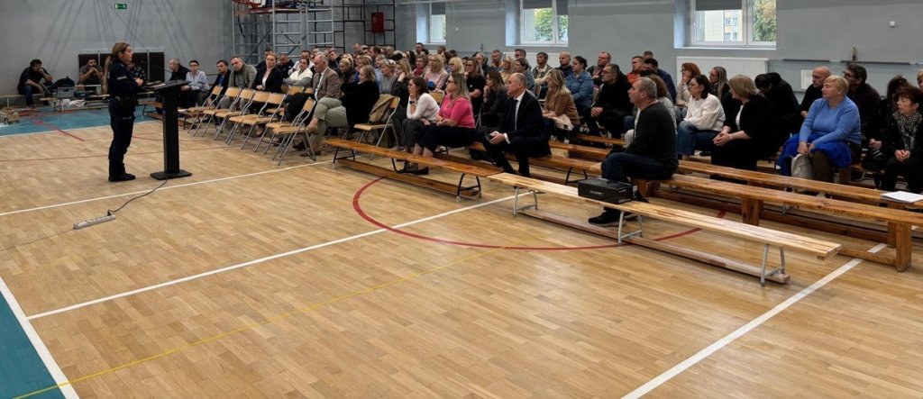Policjantka prowadzi szkolenie z bezpieczeństwa dla nauczycieli w sali gimnastycznej szkoły w Ostrołęce